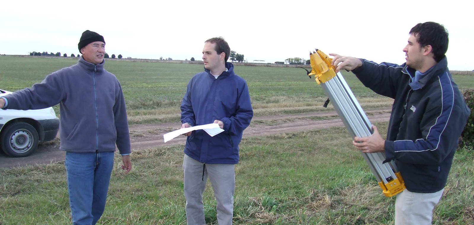 Equipo de AB Agrimensura verificando planos y equipamiento en campo
